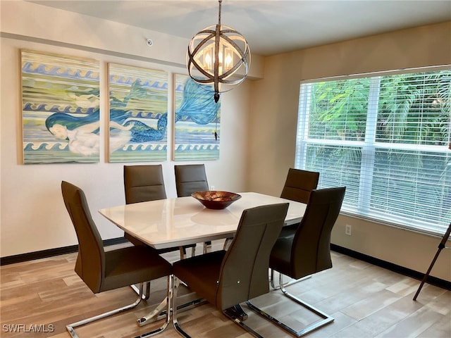 dining room with light hardwood / wood-style floors and an inviting chandelier