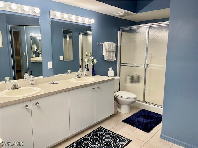 bathroom featuring vanity, an enclosed shower, toilet, and tile patterned floors