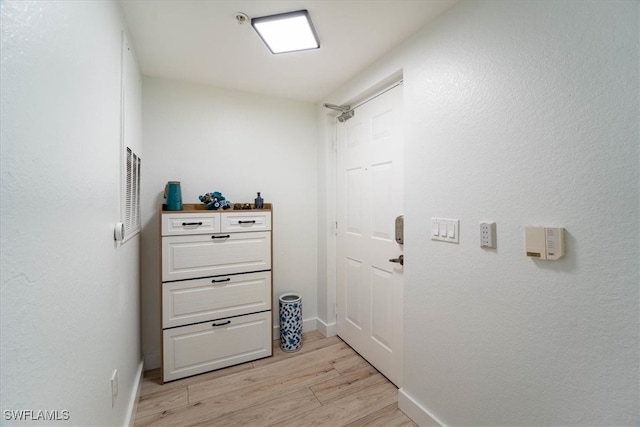 corridor with light hardwood / wood-style flooring