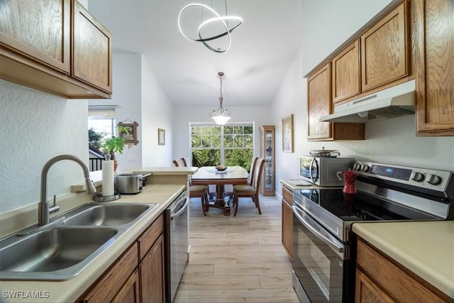 7925 Preserve Cir Unit 333, Naples, FL 34119 - kitchen featuring stainless steel appliances, under cabinet range hood, a sink, vaulted ceiling, and light wood-style flooring