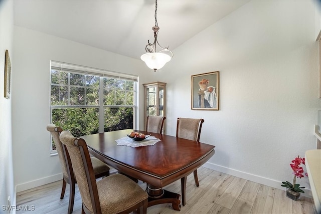 dining room featuring lofted ceiling and light hardwood / wood-style flooring