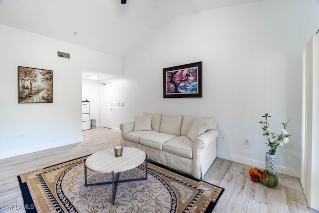 living room with light hardwood / wood-style floors and vaulted ceiling