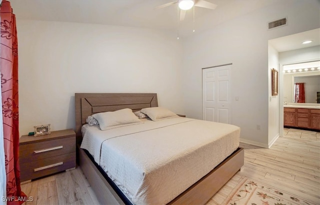 bedroom featuring light hardwood / wood-style flooring, a closet, ensuite bathroom, and ceiling fan