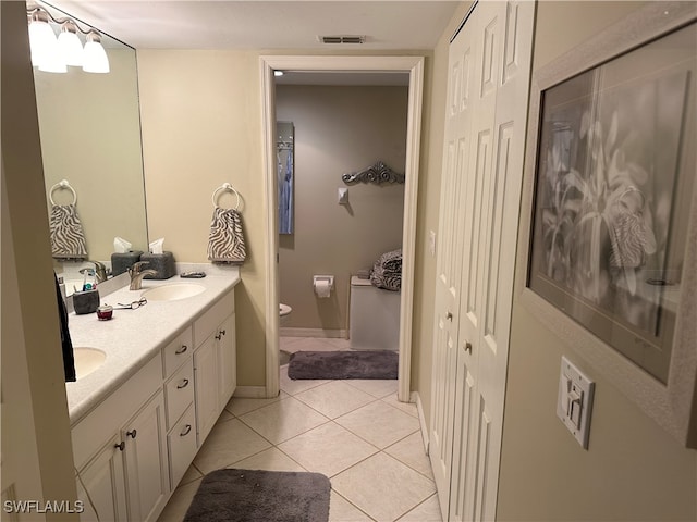 bathroom featuring vanity, tile patterned flooring, and toilet