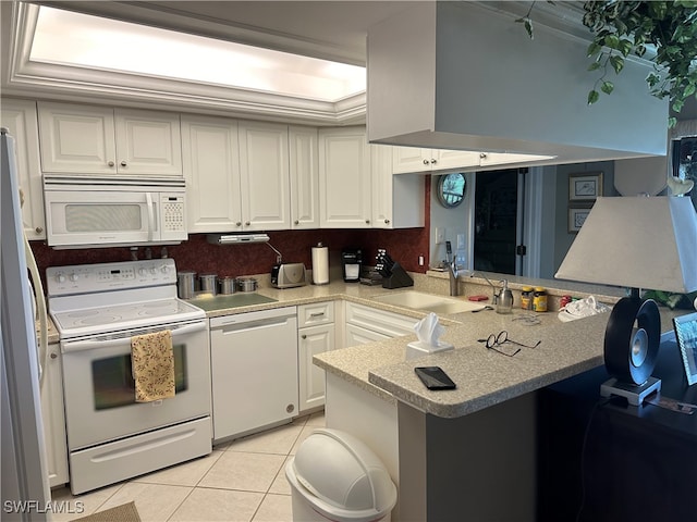 kitchen featuring light tile patterned flooring, white appliances, sink, white cabinets, and kitchen peninsula