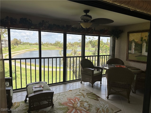 sunroom featuring a wealth of natural light, a water view, and ceiling fan