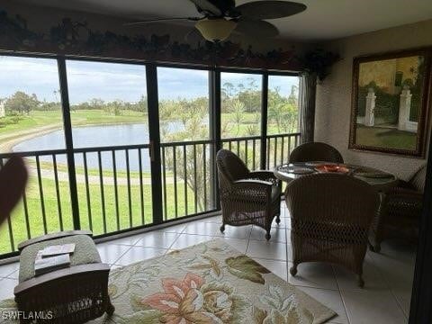 sunroom with a water view and ceiling fan