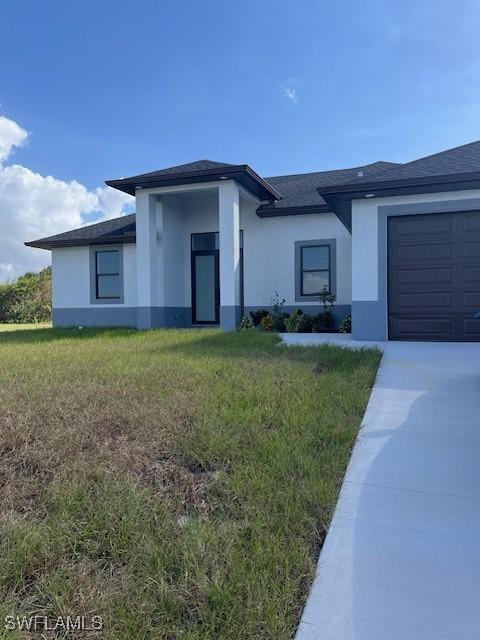 view of front of house featuring a front lawn and a garage