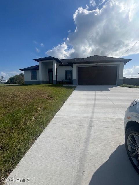 view of front of home with a front yard and a garage