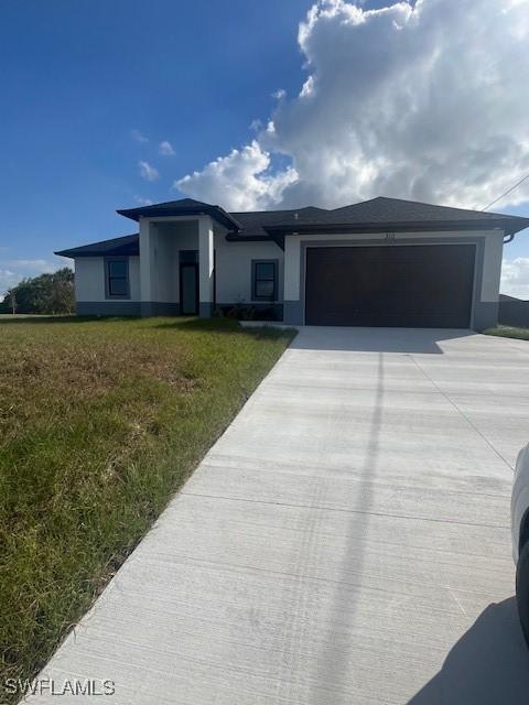 view of front of house featuring a front yard and a garage