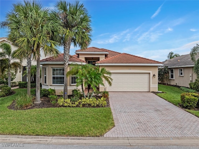 mediterranean / spanish home with a front yard and a garage