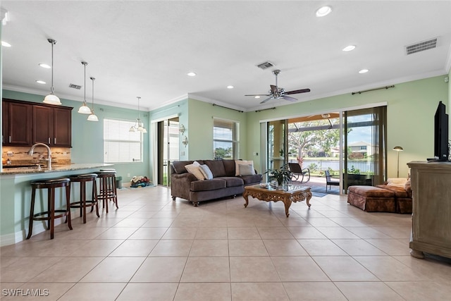 living room featuring ceiling fan, sink, ornamental molding, and light tile patterned flooring