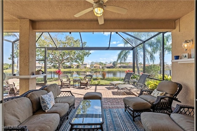 view of patio / terrace featuring a water view, ceiling fan, and a lanai