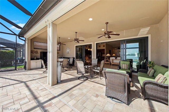 view of patio featuring exterior kitchen, an outdoor hangout area, outdoor dining area, and a ceiling fan