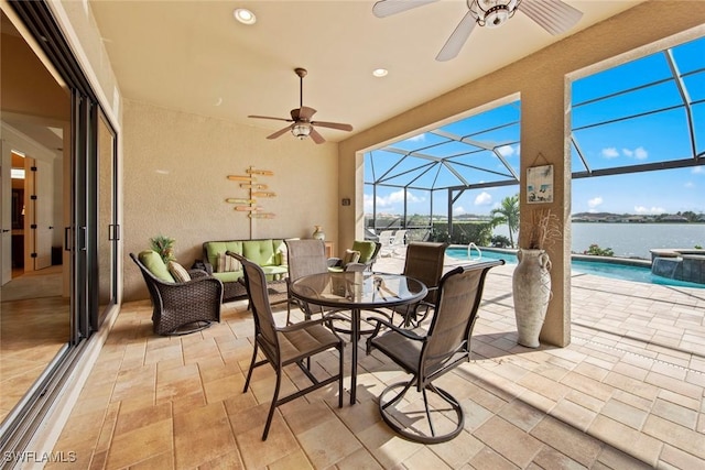 view of patio with a ceiling fan, a lanai, a water view, and an outdoor pool