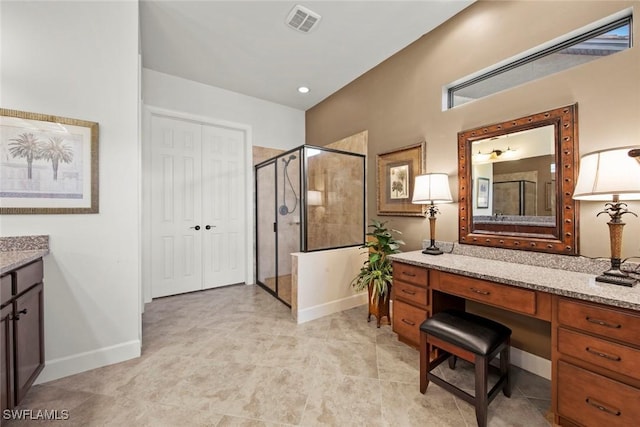 bathroom featuring visible vents, a stall shower, vanity, and baseboards