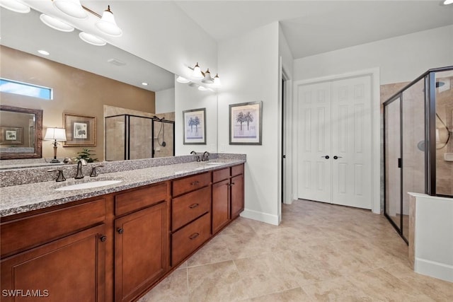 bathroom featuring double vanity, a stall shower, baseboards, and a sink