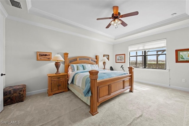 bedroom featuring crown molding, a raised ceiling, and light colored carpet