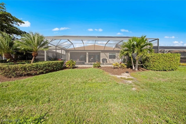 rear view of house featuring a lanai and a yard