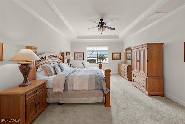 bedroom with ceiling fan, light carpet, baseboards, a tray ceiling, and crown molding