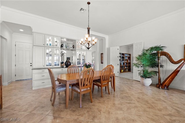 dining area featuring crown molding, baseboards, visible vents, and an inviting chandelier