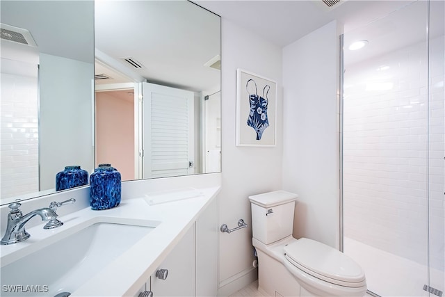 bathroom with vanity, toilet, and a shower