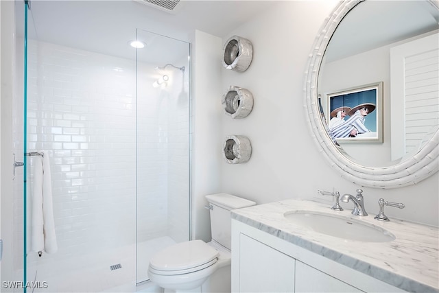 bathroom with vanity, a shower with door, and toilet