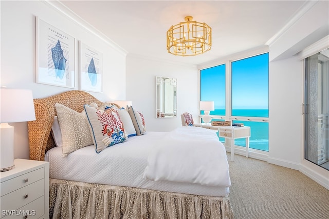 carpeted bedroom featuring an inviting chandelier, ornamental molding, and a water view