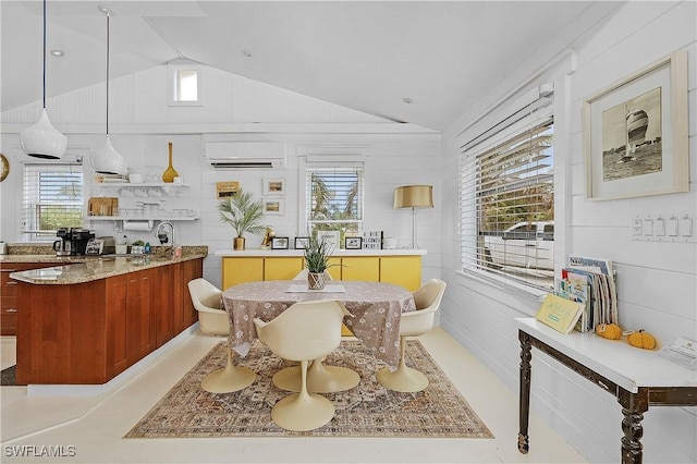 dining area featuring vaulted ceiling, plenty of natural light, and a wall unit AC