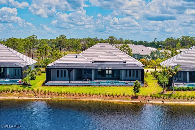 back of property featuring a patio, a lawn, and a water view