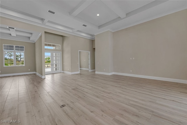 spare room with beam ceiling, ornamental molding, french doors, and light wood-type flooring