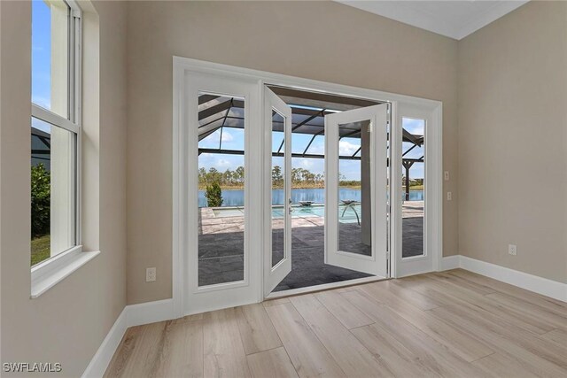 doorway to outside featuring a water view and light wood-type flooring