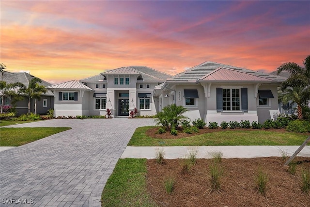 8871 Nevis Way, Naples, FL 34112 - view of front of property with a standing seam roof, stucco siding, a front lawn, and decorative driveway