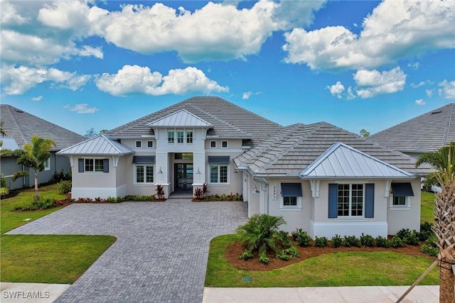 8871 Nevis Way, Naples, FL 34112 - view of front facade featuring decorative driveway, stucco siding, french doors, and a standing seam roof