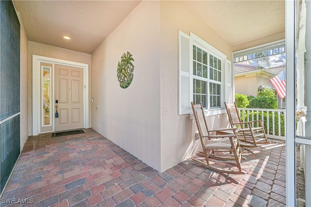 view of exterior entry featuring covered porch