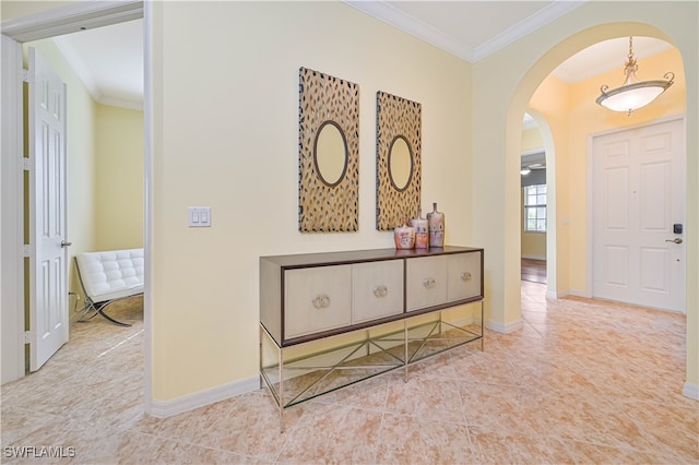 foyer with crown molding and light tile patterned floors