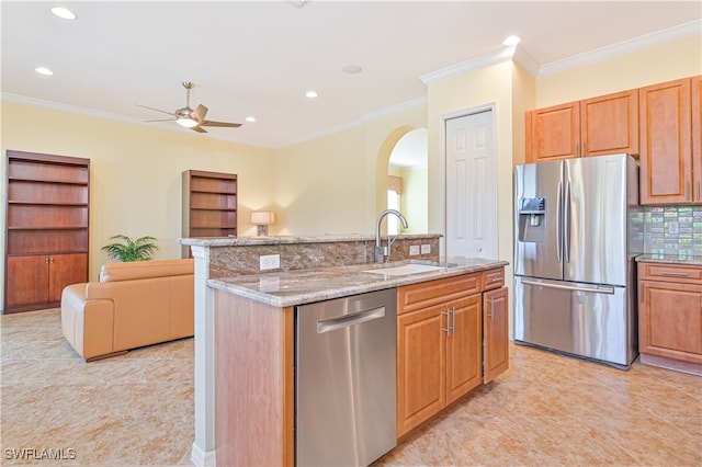 kitchen featuring appliances with stainless steel finishes, sink, a center island with sink, and ornamental molding