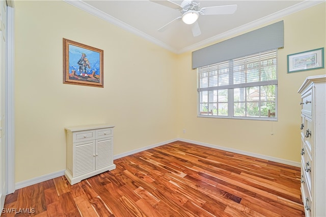 empty room with ornamental molding, light wood-type flooring, and ceiling fan