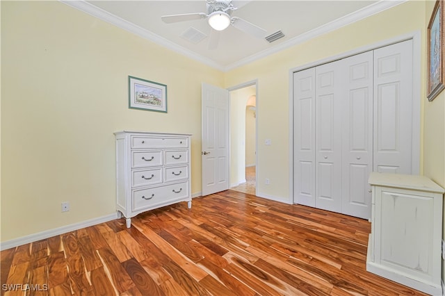 unfurnished bedroom with light hardwood / wood-style flooring, a closet, crown molding, and ceiling fan