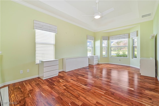 unfurnished room featuring ornamental molding, wood-type flooring, a tray ceiling, and ceiling fan