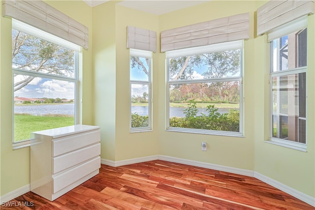 unfurnished sunroom featuring a wealth of natural light and a water view