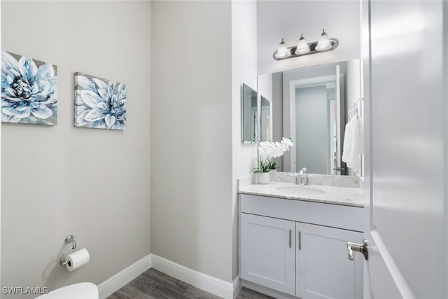 bathroom featuring vanity, hardwood / wood-style floors, and toilet