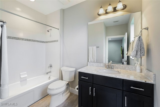 full bathroom with vanity, toilet, tiled shower / bath combo, and hardwood / wood-style floors