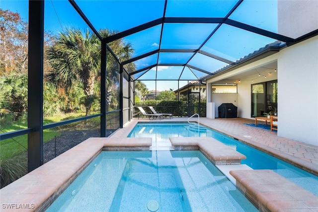 view of swimming pool featuring an in ground hot tub, a patio area, area for grilling, and glass enclosure