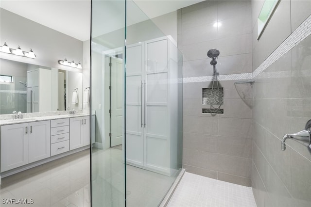 bathroom featuring vanity, a tile shower, and tile patterned floors