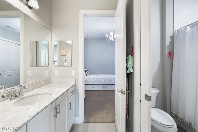 bathroom featuring vanity, toilet, and a chandelier