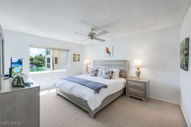 carpeted bedroom featuring a textured ceiling and ceiling fan