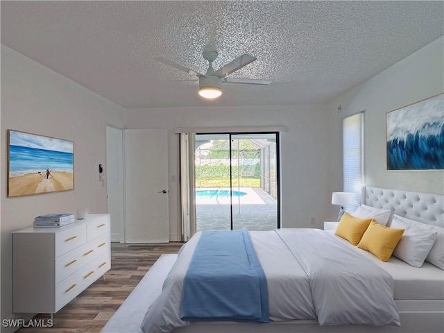 bedroom with access to exterior, a textured ceiling, ceiling fan, and dark wood-type flooring