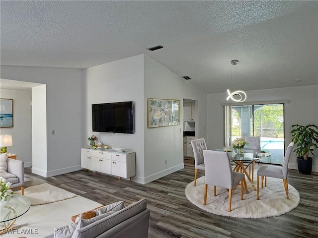 dining space with dark hardwood / wood-style flooring, a textured ceiling, and vaulted ceiling