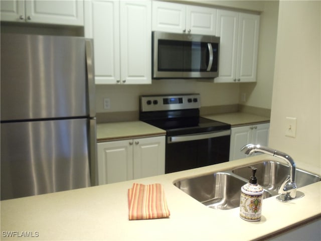 kitchen featuring appliances with stainless steel finishes, white cabinets, and sink